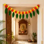 Yellow and orange marigold toran with artificial mango leaves for a doorway