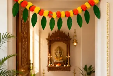 Yellow and orange marigold toran with artificial mango leaves for a doorway