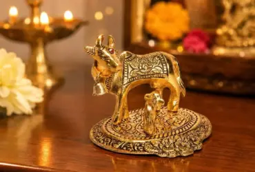 Decorative gold-coloured cow and calf statue on a base