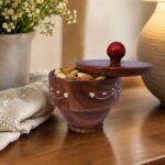 Decorative wooden bowl with matching lid and carved details